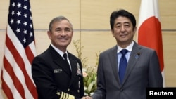 FILE - Japan's Prime Minister Shinzo Abe shakes hands with US Navy Admiral Harry B. Harris Jr., commander of the United States Pacific Command, before talks at Abe's official residence in Tokyo, Japan, Feb. 16, 2016.