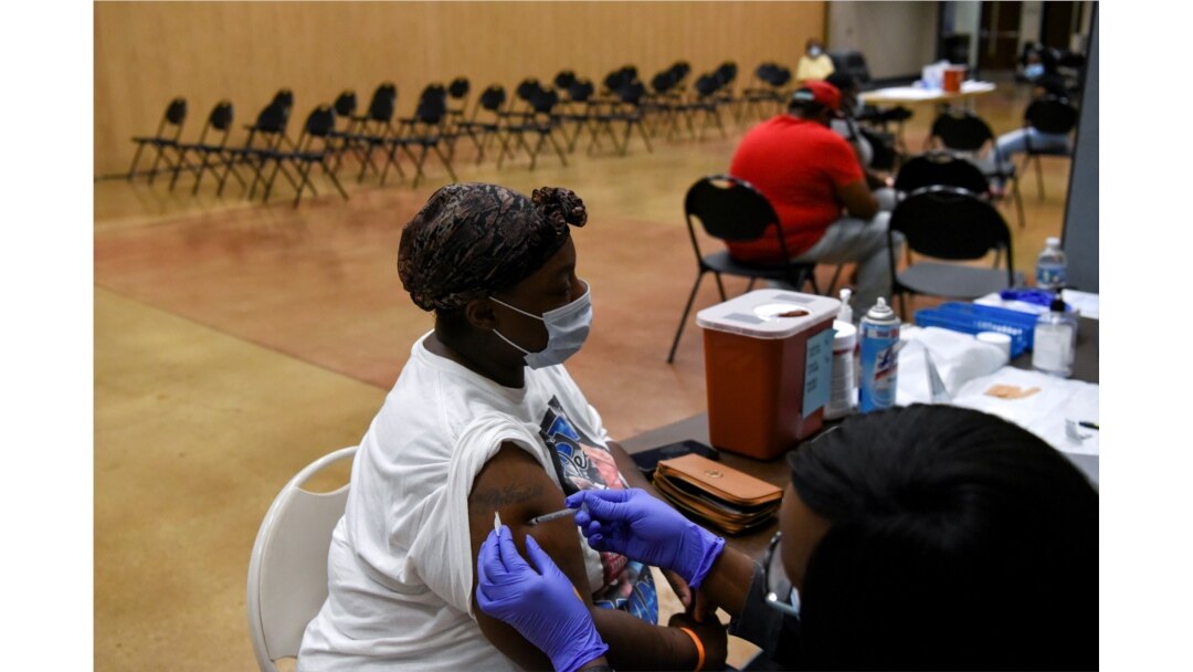 A person receives a vaccine for COVID-19 at Acres Home Multi-Service Center in Houston, Texas, October 13, 2021.