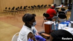 A person receives a vaccine for COVID-19 at Acres Home Multi-Service Center in Houston, Texas, October 13, 2021. 