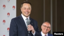 South Australian Premier Jay Weatherill, right, listens to Tesla Chief Executive Officer Elon Musk speak during an official ceremony in Adelaide, Australia, July 7, 2017. to announce that Tesla will install the world's largest grid-scale battery in the South Australian state.