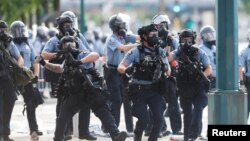 منی ایپلس میں پولیس اہل کار ، سیاہ فام امریکی جارج فلائیڈ کی ہلاکت کے خلاف مظاہرہ کرنے والوں کو منتشر کرنے کی کارروائی کر رہی ہے۔ 27 مئی 2020