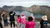 FILE - Chinese tourists take in the sight from a viewing platform overlooking the caldera of Mount Paektu near Samjiyon in North Korea, Aug. 18, 2018.