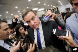 FILE - Senate Intelligence Committee Vice Chairman Sen. Mark Warner, D-Va., whose panel is investigating Russian interference in the 2016 election, speaks with reporters at the Capitol in Washington.