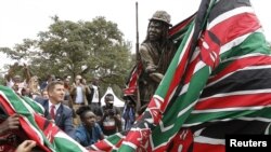 Christian Turner (L), British High Commissioner to Kenya, unveils the statues during the inauguration of a memorial to victims of torture and ill-treatment by the British colonialists during the Kenya “Emergency” at Uhuru Park's Freedom Corner, in Nairobi