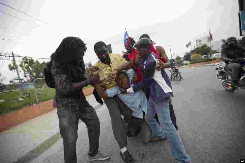 Lindor Kerby, wartawan Radio Tele Timoun, dibantu oleh para demonstran setelah pasukan penjaga perdamaian PBB dari Brazil melepaskan gas air mata untuk membubarkan protes menentang dewan pemilu negara tersebut, memperingati 25 tahun pemilu demokratis pertama pada tahun 1990, di Port-au-Prince, Haiti, 16 Desember 2015. Hasil pemilu yang diperdebatkan kembali menimbulkan gelombang protes di jalan dan tuduhan kecurangan pemilu dari masyarakat dan kelompok oposisi.