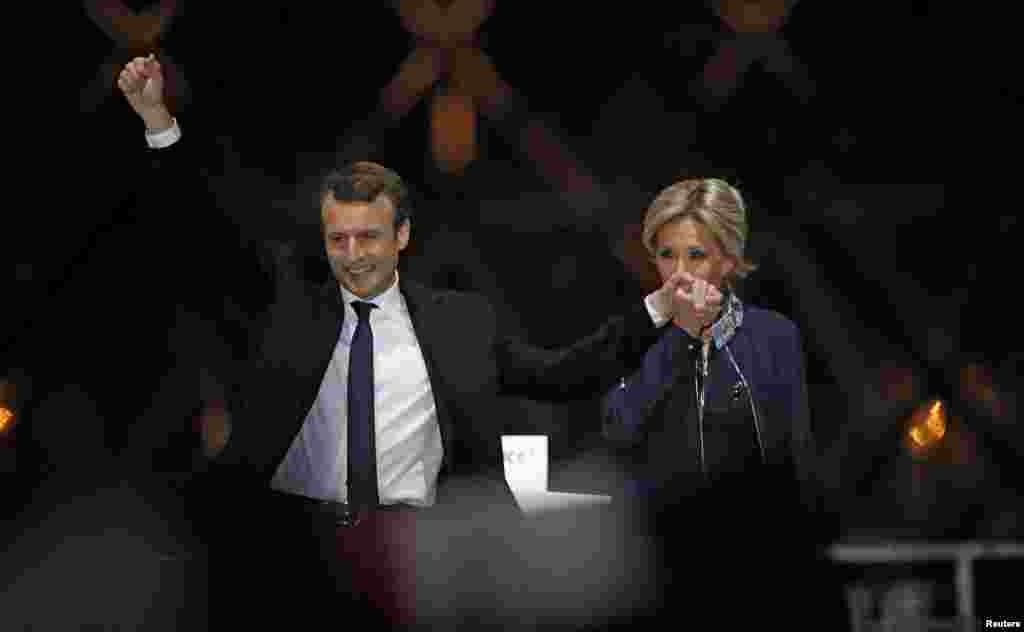 French President-elect Emmanuel Macron and his wife Brigitte Trogneux celebrate on stage at his victory rally near the Louvre in Paris, France, May 7, 2017.