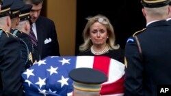 Rep. Debbie Dingell, D-Mich., watches the flag-draped casket of former Rep. John Dingell upon arrival at Holy Trinity Catholic Church for a funeral service, Feb. 14, 2019, in Washington. 