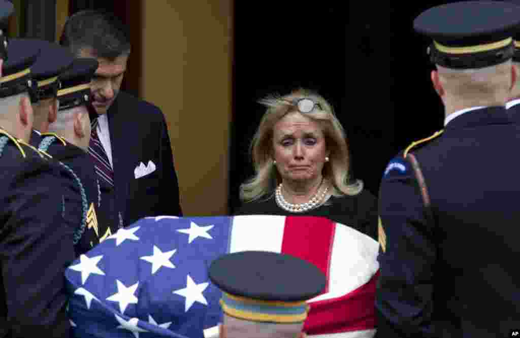 Rep. Debbie Dingell, D-Mich., watches the flag-draped casket of her late husband former Rep. John Dingell upon arrival at Holy Trinity Catholic Church for a funeral service, in Washington. Dingell, the longest-serving member of Congress in American history who mastered legislative deal-making and was fiercely protective of Detroit&#39;s auto industry, has died at age 92.