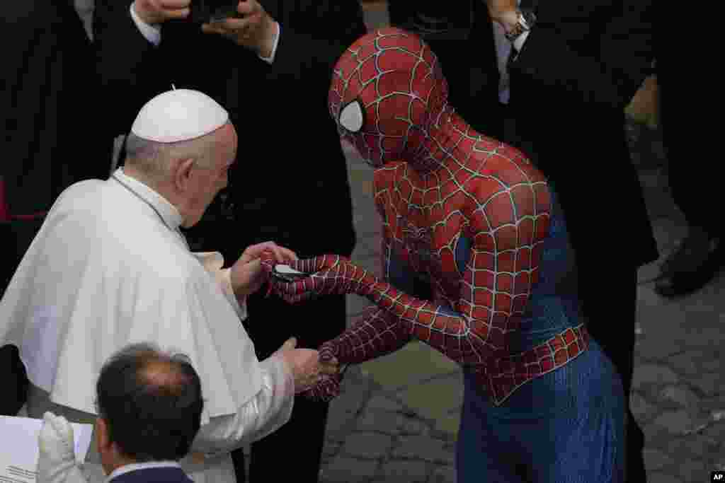 Pope Francis meets Spider-Man, who presents him with his mask, at the end of his weekly general audience with a limited number of faithful in the San Damaso Courtyard at the Vatican.