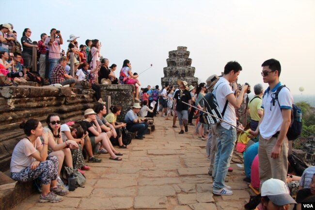 រូបឯកសារ៖ ភ្ញៀវ​ទេសចរ​ជាតិ​និង​អន្តរជាតិ​ថត​រូប​ទេស​ភាព​ថ្ងៃ​លិច​នៅ​លើ​កំពូល​ប្រាសាទ​ភ្នំ​បាក់ខែង​ ខេត្ត​សៀមរាប កាល​ពី​ល្ងាច​ថ្ងៃ​ទី​២១​ ខែ​មីនា​ ឆ្នាំ​២០១៥។ (នូវ​ ពៅ​លក្ខិណា​/VOA)