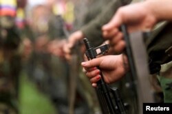 FILE - A fighter of the Revolutionary Armed Forces of Colombia (FARC) participates in a parade in the Villa Colombia camp near San Vicente del Caguan,Caqueta province, Colombia, April 29, 2000.