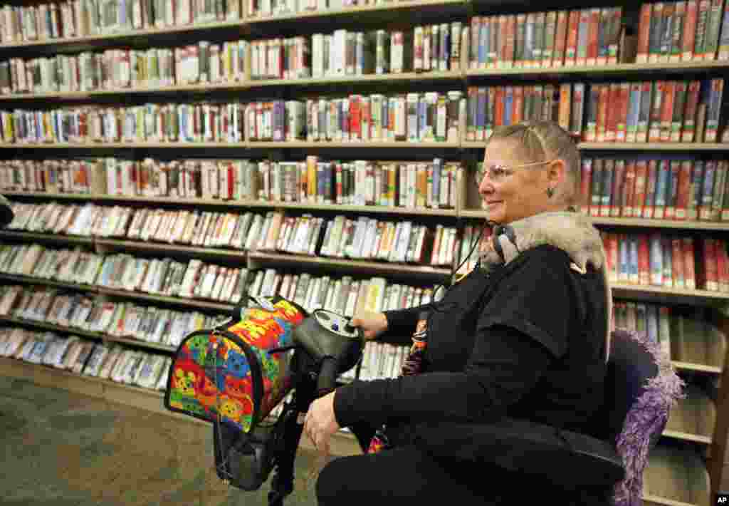 Dani Moore keeps her service rat, Hiyo Silver on a leash in the public library in Hesperia, Ca. in this 2011 file photo.