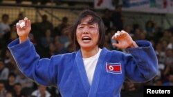 North Korea's An Kum Ae celebrates after defeating Cuba's Yanet Bermoy Acosta in their women's -52kg final judo match at the London 2012 Olympic Games July 29, 2012.