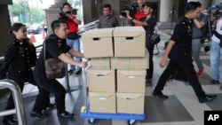 FILE - In this Wednesday, Aug. 28, 2019, file photo, Malaysian Anti-Corruption agency's staff transport documents for 1MDB case to Kuala Lumpur high court in Kuala Lumpur, Malaysia.