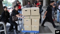 FILE - In this Wednesday, Aug. 28, 2019, file photo, Malaysian Anti-Corruption agency's staff transport documents for 1MDB case to Kuala Lumpur high court in Kuala Lumpur, Malaysia. 