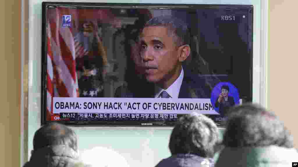 Des spectateurs regardent un programme de nouvelles de TV montrant le président Barack Obama, à la gare de Séoul à Séoul, Corée du Sud, le 22 décembre 2014.