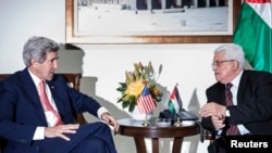 U.S. Secretary of State John Kerry (L) and Palestinian president Mahmoud Abbas talk before a meeting at the presidential compound in the West Bank city of Ramallah on January 3, 2014.