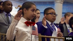 Moroccan-American Sara, left, and Zambian-American Chonza Chingwe recite the “Oath of Allegiance,” during a citizenship ceremony in New York, May 5, 2017. (R. Taylor/VOA)