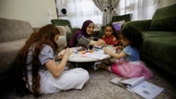 Ibu tunggal Irak Marwa Raed Taha, duduk bersama putrinya dan anak-anak kerabatnya di rumahnya, di Baghdad, Irak, 9 Mei 2021. (Foto: REUTERS/Saba Kareem)