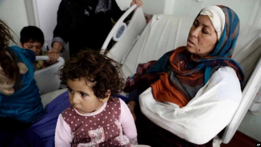 FILE - Um Yousef and her children recover in an Irbil hospital after they were badly injured in a mortar attack outside their home in Mosul, Iraq, Jan. 15, 2017.
