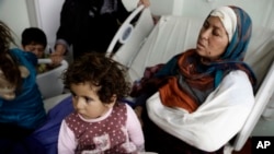 FILE - Um Yousef and her children recover in an Irbil hospital after they were badly injured in a mortar attack outside their home in Mosul, Iraq, Jan. 15, 2017.