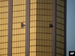 FILE - In this Oct. 2, 2017 file photo, drapes billow out of broken windows at the Mandalay Bay resort and casino on the Las Vegas Strip, following a mass shooting at a music festival in Las Vegas.