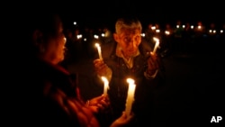 An elderly exile Tibetan participates in a candle-lit vigil in solidarity with fellow Tibetans who have self immolated, in Katmandu, Nepal, Feb. 13, 2013. 