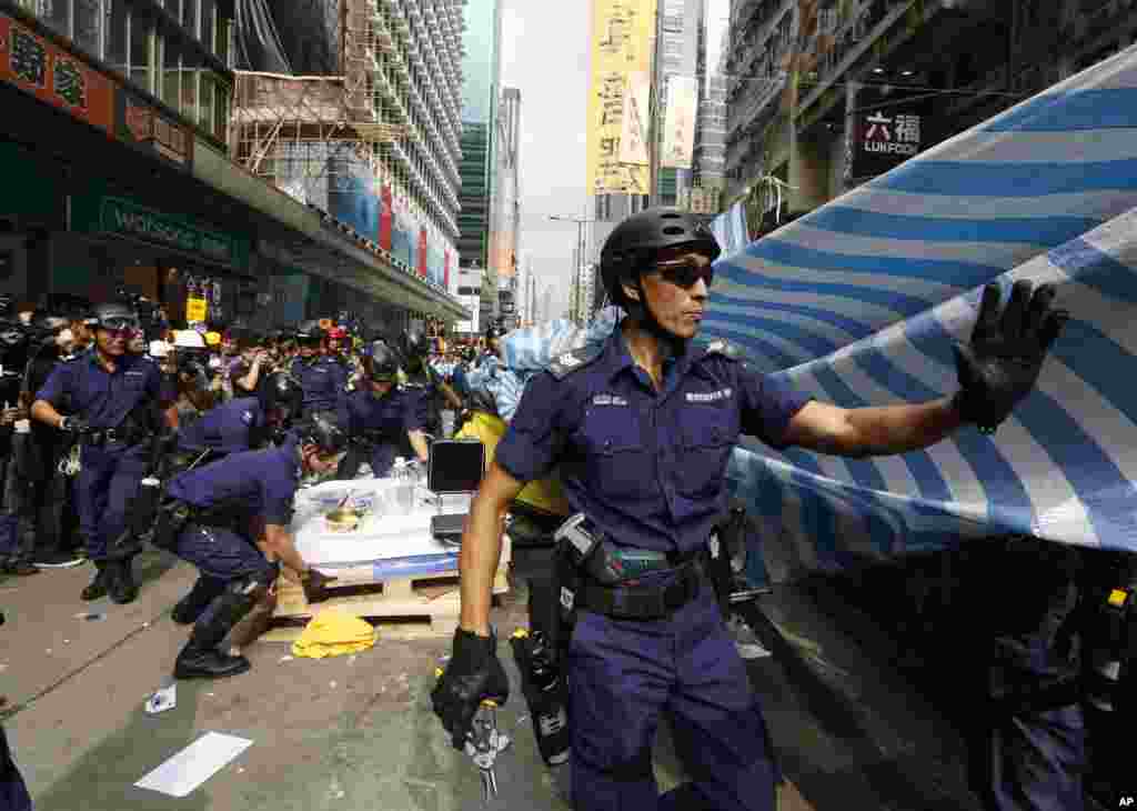 Police officers clear a protest site after warning the crowd that they would start enforcing the court-ordered clearance at an occupied area in Mong Kok district of Hong Kong, Nov. 26, 2014.