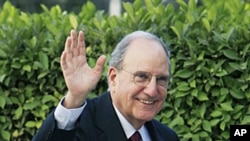 US Mideast envoy George Mitchell waves his hand to reporters while arriving at the Arab League headquarters in Cairo, Egypt, Dec. 15, 2010.