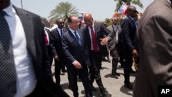 France's President Francois Hollande, center left, and Haiti's President Michel Martelly walk at the National Palace in Port-au-Prince, Haiti, Tuesday, May 12, 2015.