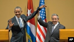 Prezidan Raul Castro (adwat) leve bra Prezidan Obama nan fen yon konferans pou lapròs 2 lidè yo bay nan apremidi jounen lendi 21 mas 2016 la nan La Avàn
