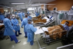 Medical workers take care of patients in the emergency room of the Nossa Senhora da Conceicao hospital that is overcrowding because of the coronavirus disease (COVID-19) outbreak, in Porto Alegre, Brazil, March 11, 2021. REUTERS/Diego Vara