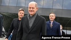 German Chancellor-designate Olaf Scholz, center, and represenatives of ruling coalition parties leave the Futurium venue after a signing ceremony in Berlin, Dec. 7, 2021. 