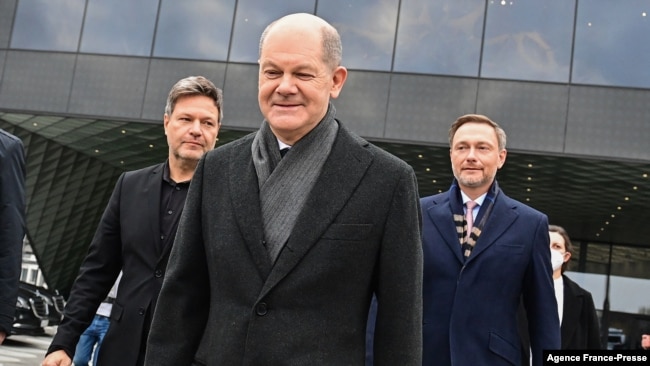 German Chancellor-designate Olaf Scholz, center, and represenatives of ruling coalition parties leave the Futurium venue after a signing ceremony in Berlin, Dec. 7, 2021.
