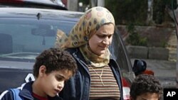 An Egyptian mother collects her sons outside a school in Cairo, April 4, 2011. During the recent mass uprising, as much as fifty percent of police disappeared from cities and their withdrawal has created a security vacuum, letting crime flourish.