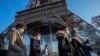 На фото: Люди у масках прогулюються поблизу Ейфелевої вежі у Парижі. Грудень 2021