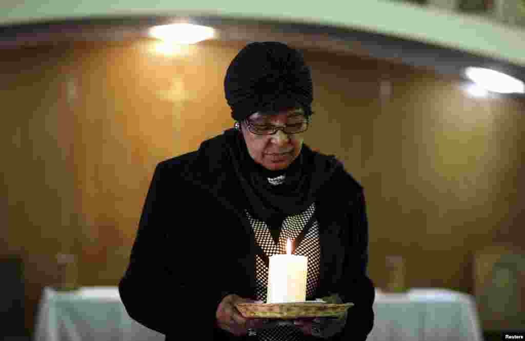 Winnie Madikizela-Mandela, ex-wife of former South African President Nelson Mandela, holds a candle during a prayer service for the ailing Mandela at a church in Johannesburg, July 5, 2013.&nbsp;