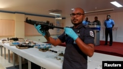 A Maldives police officer shows weapons found during investigations into a Sept. 28 blast on a speedboat transporting Maldives President Abdulla Yameen, October 31, 2015.