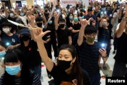 Para pemrotes anti-pemerintah berkumpul dalam sebuah demonstrasi di dalam sebuah mal di distrik Sha Tin dalam solidaritas dengan para mahasiswa pemrotes yang ditembak oleh polisi dengan amunisi langsung di Hong Kong, Cina, 2 Oktober 2019. (Foto: Reuters/Athit Perawongmetha)