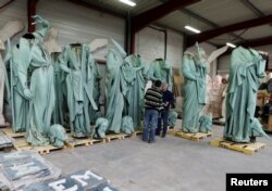 Consultant Patrick Palem (R) checks statues that were removed from the spire of Paris' Notre-Dame Cathedral in a workshop at the Socra company for restoration work in Marsac-sur-L'Isle, France, April 16, 2019.