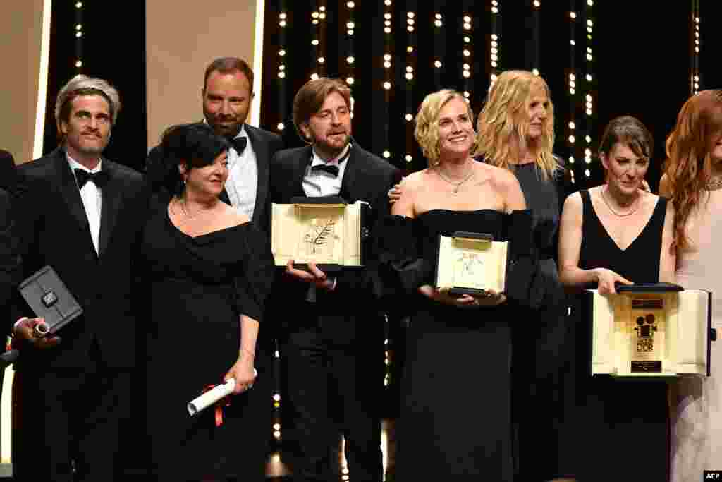 (From L) Best Actor prize laureate US actor Joaquin Phoenix, Best Screenplay co-laureates British director Lynne Ramsay and Greek director Yorgos Lanthimos, Palme d&#39;Or laureate Swedish director Ruben Ostlund, Best Actress Prize laureate German actress Diane Kruger, French actress and President of the Camera d&#39;Or jury Sandrine Kiberlain, Camera d&#39;Or laureate French director Leonor Serraille and French actress Laetiti Dosch pose on stage on May 28, 2017 at the end of the closing ceremony of the 70th edition of the Cannes Film Festival in Cannes, southern France.