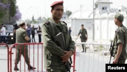 A Tunisian army officer stands guard outside the Bouchoucha military base after shooting in Tunis, Tunisia, May 25, 2015. 