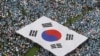 FILE - People carry a large scale South Korean national flag during an anti-North Korea rally marking Memorial Day in Seoul, June 6, 2011