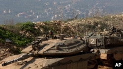 FILE - Israeli soldiers sit in tanks near the in Israel-Lebanon border, northern Israel, Jan. 20, 2015. Israel is on continuous alert for possible attacks from the Lebanon-based militant group Hezbollah.