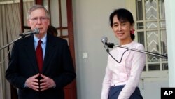 FILE - U.S. Senator Mitch McConnell, left, talks as then-Myanmar pro-democracy leader in opposition Aung San Suu Kyi listens during a press conference after their meeting at her home in Yangon, Myanmar, Jan. 16, 2012.