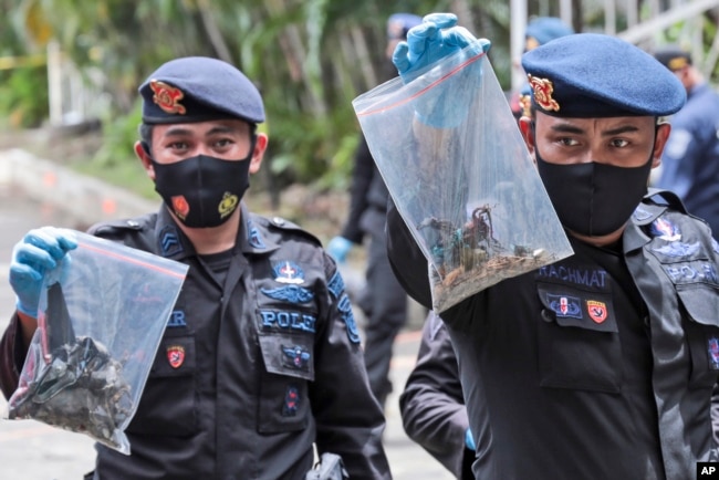 Polisi menunjukkan tas plastik berisi barang bukti yang dikumpulkan dari lokasi ledakan di Gereja Katedral, Makassar, Senin (29/3).