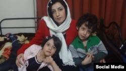 FILE - Narges Mohammadi, an Iranian human rights advocate, who is serving her jail term, is seen along with her two children in their home in Tehran.