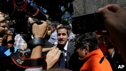 Supporters of opposition leader Juan Guaido and the press gather around him as he leaves a public plaza where he spoke in Caracas, Venezuela, Jan. 25, 2019.