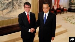 Japanese Foreign Minister Taro Kono, left, and Chinese Premier Li Keqiang pose for a photo before their meeting at the Zhongnanhai Leadership Compound in Beijing, Jan. 28, 2018. 