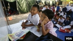 Anak-anak belajar di tenda darurat di sebuah kamp pengungsi di Kediri, Jawa Timur (foto: tahun 2007). Diperkirakan sekitar 11.7 juta anak Indonesia belum tersentuh pendidikan.